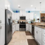 Step-saver kitchen with granite counters, stainless appliances, pantry and plenty of cabinetry.