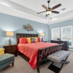 Primary bedroom with door out to the upper deck with seating.