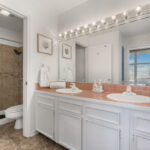 Owner's bath area with walk-in shower and two sinks.