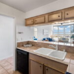 Kitchen looking toward dining/living and out to the pool. Door to the left is the storage room with air handler.