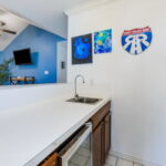 The wet bar includes a stainless-steel mini refrigerator.