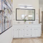 The hall bath has dual sinks, tile flooring and beautiful shower.