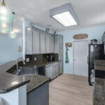 Kitchen is open to view the living area and water.