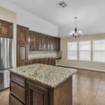 Kitchen is well equipped with an island and stainless steel appliances.