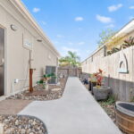 Side yard w/ sidewalk and outdoor shower
