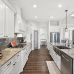 Granite counters, gas stove top, sparkling stainless appliances.