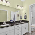 Guest bath with 2 vanities and tub/shower combo.