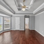 This primary bedroom is spacious. Crown molding and vinyl wood flooring.