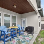 Covered back patio with decorative wood ceiling.