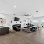 THIRD FLOOR - Living area or game room, fireplace, wet bar, and doors out to the patio with WATER views!!