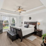 Primary bedroom with views out to the water and pool.