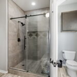 Updated walk-in shower with unique tile accent.
